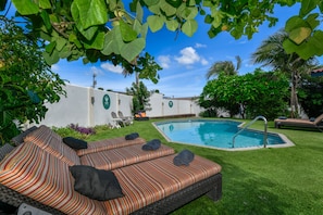 A pool area with a lounge chair and a small pool. - ALOE B&B (Oranjestad)