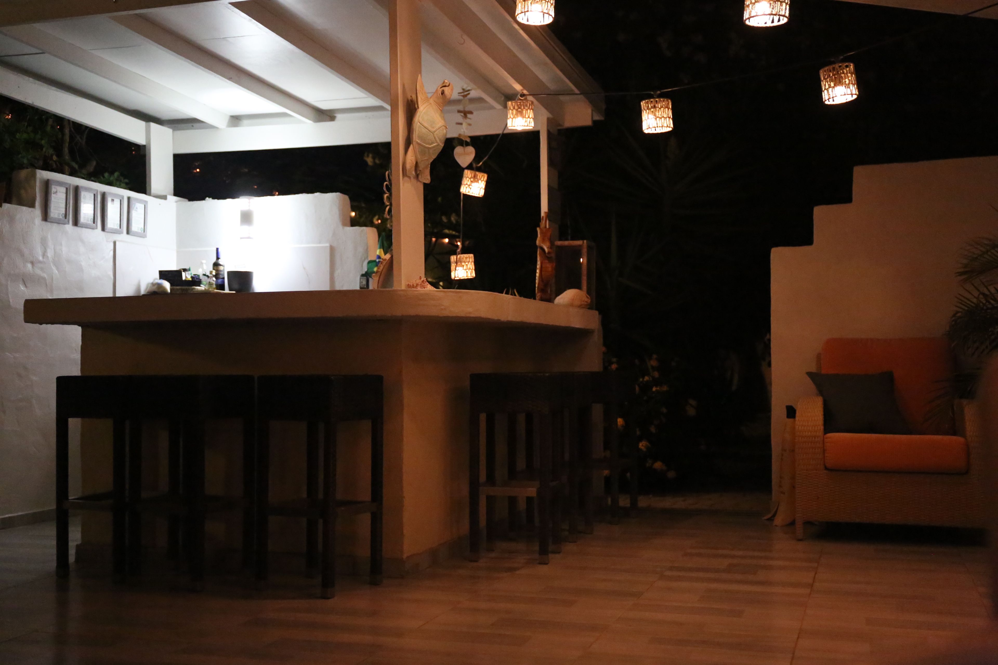 Eine Bar mit Hockern, einer Theke und hängenden Lampen.