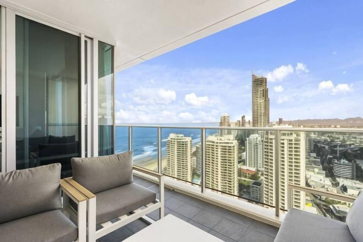 A balcony with a city view, a glass door, and a sofa.
