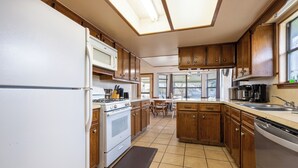 Una cocina con armarios de madera, un refrigerador blanco, una estufa y un lavavajillas.