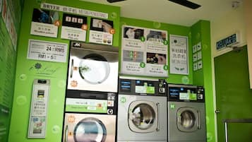 A laundromat with multiple washing machines, a dryer, and coin-operated machines.