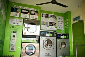 Eine Waschsalon mit mehreren Waschmaschinen, einem Trockner und Münzautomaten.