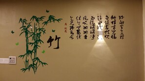 Eine Wand mit Kalligraphie und Bambusdekoration.