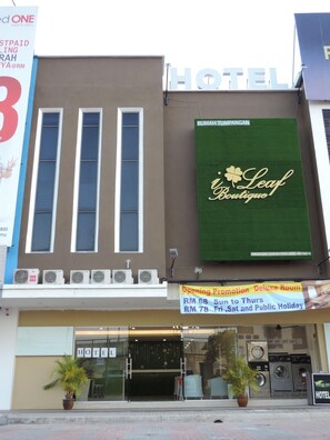 Ein Hotel mit einer großen Schautafel für ein Boutique-Hotel namens 'Leaf Boutique Hotel'.
