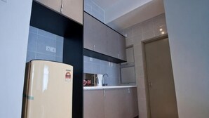 Una cocina con refrigerador, armarios y una puerta.