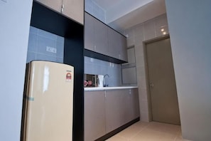 A kitchen with a refrigerator, cabinets, and a door. - DreamScape Apartment @ Golden Hill (Brinchang)