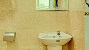 Une salle de bain équipée d’un lavabo, d’un sèche-mains et d’un miroir.