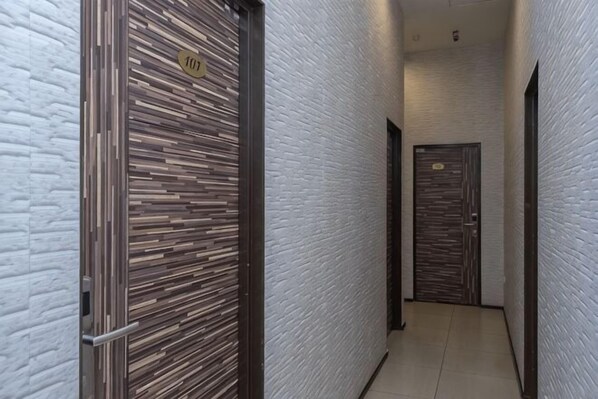 Um corredor com duas portas, uma com padrão listrado e outra com design em madeira.