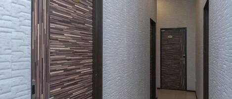 A narrow hallway with two doors, one with a number plate and the other with a keypad.