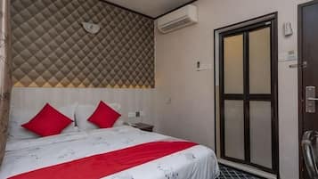Quarto de hotel com uma cama, uma porta e uma parede com padrão geométrico.