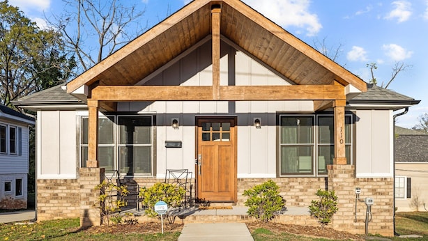 A two-story house with a gabled roof, a front porch, and a brick exterior. - 3BR Walkable Downtown Retreat ~ King Bed + Porch (Salisbury)
