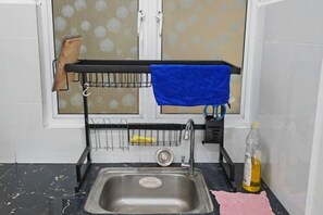A kitchen with a stainless steel sink, a dish rack, and a blue towel hanging on the wall. - Sweet Homestay Suite 3BD Room@Simfoni Kuah (Langkawi)