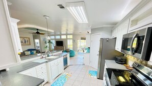 Un'ampia cucina con isola centrale, elettrodomestici moderni e vista sull'area pranzo.