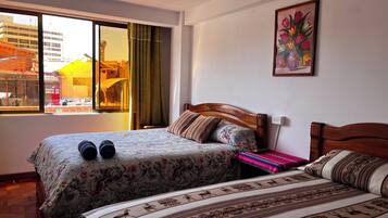 Habitación de hotel con dos camas, una ventana con cortinas, un cuadro en la pared y vistas al exterior.
