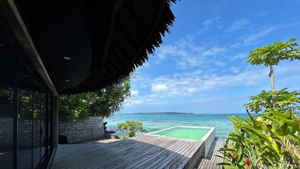 A wooden deck with a pool, overlooking a turquoise sea and a clear sky. - Black Pearl Resort  (Saraotou)