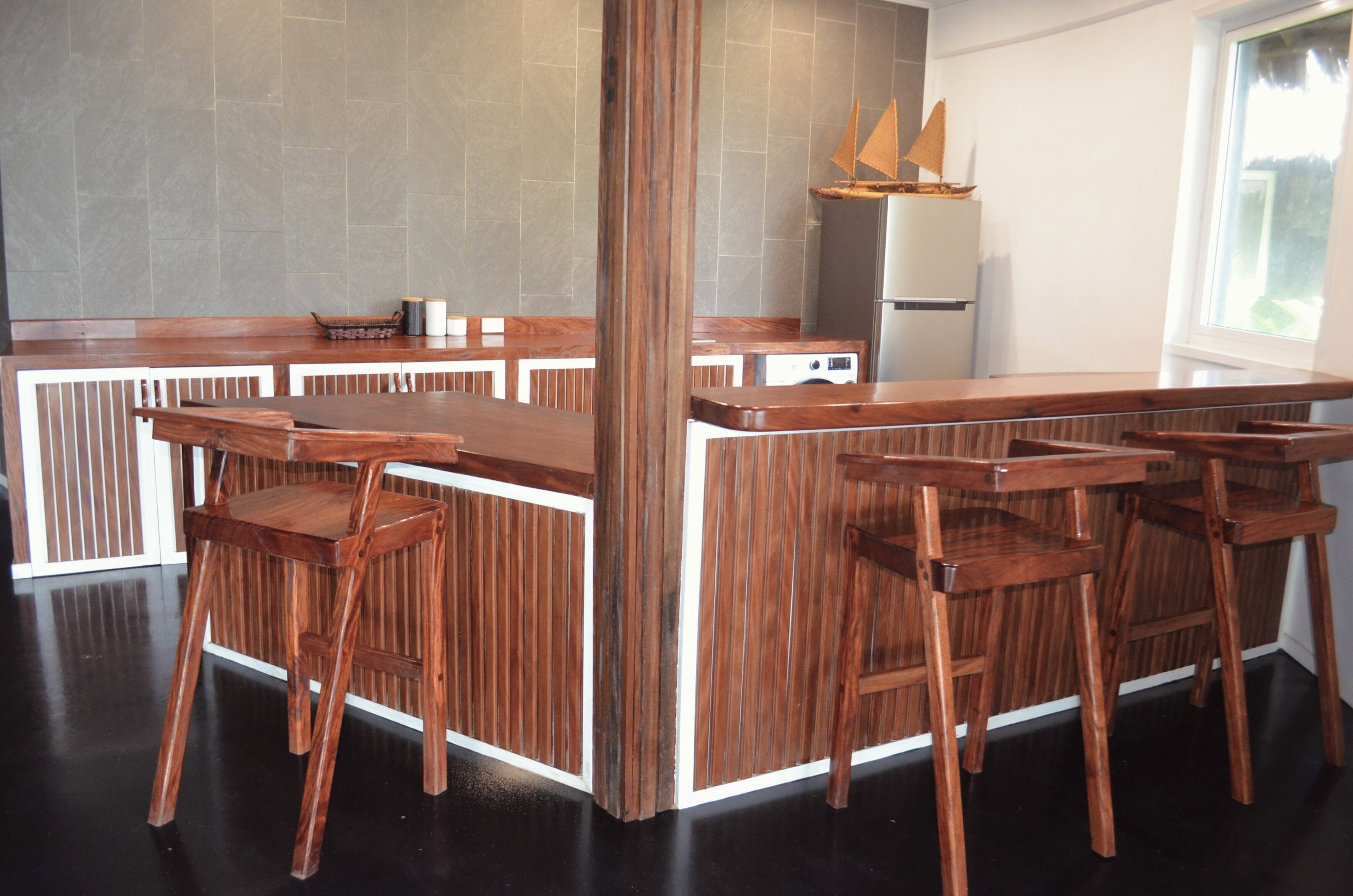 A bar area with wooden bar stools and a high counter.