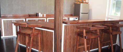 A bar area with wooden bar stools and a high counter.