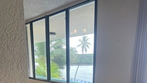 A small room with a window overlooking a body of water and palm trees. There are two chairs and a small table. - NEW LISTING- Ideal Oceanside Location and Recent Renovation / DREAM Combination! (St Thomas)