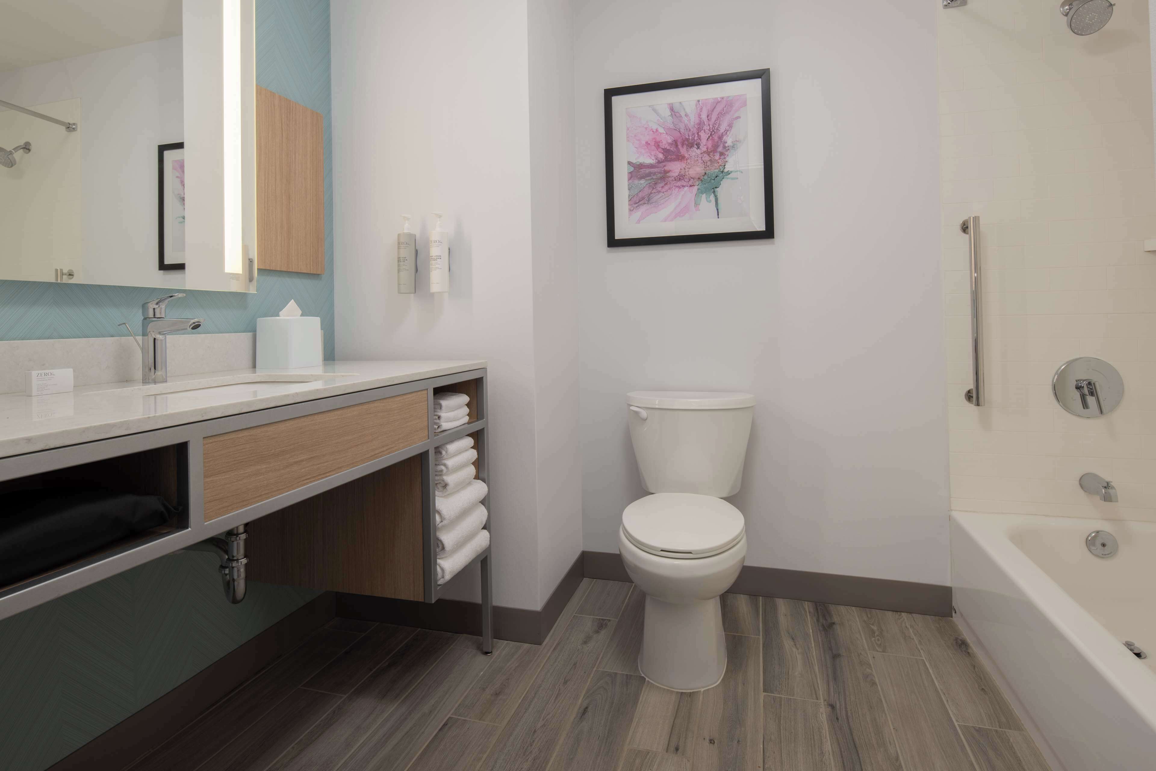 A modern bathroom with a toilet, sink, and bathtub.