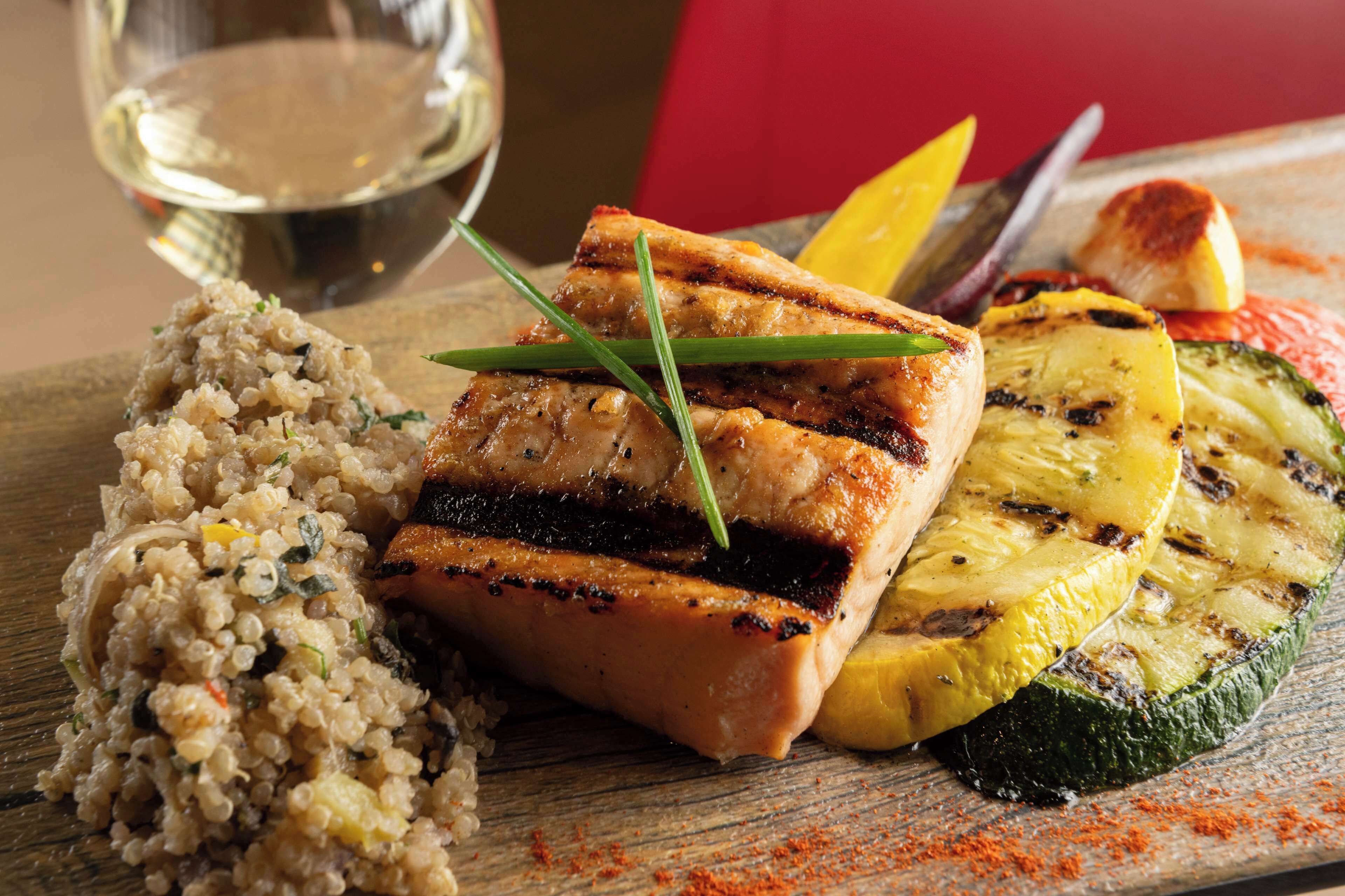 A meal with grilled salmon, grilled vegetables, and quinoa.