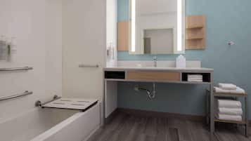 Un baño moderno con una bañera, un lavamanos con espejo y un perchero para toallas.