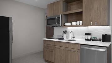 Una cocina moderna con armarios de madera, un refrigerador de acero inoxidable, un microondas y un lavavajillas.
