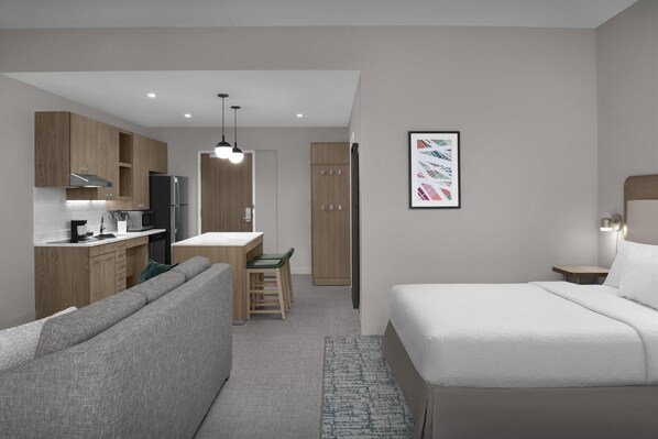 A modern hotel room with a kitchenette, a sofa, a bed, and a desk. - Homewood Suites By Hilton Columbia Downtown (Columbia)