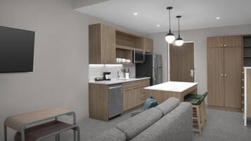 Une cuisine moderne avec des meubles en bois, un four à micro-ondes encastré et un réfrigérateur. On y trouve également un coin repas avec une table et des chaises.
