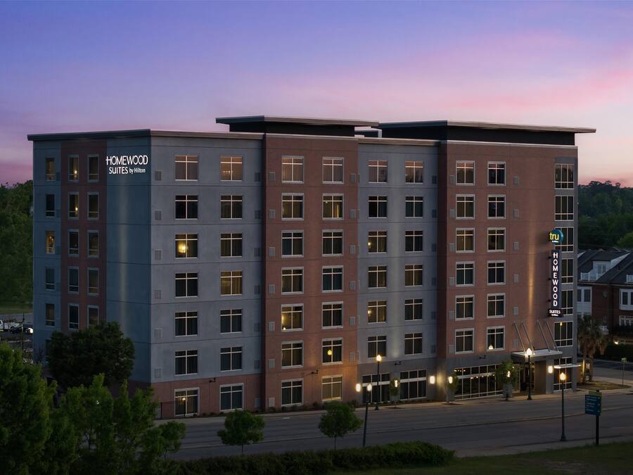 A multi-story hotel with a modern design, featuring a mix of brick and glass facades, and a prominent entrance with a covered walkway.