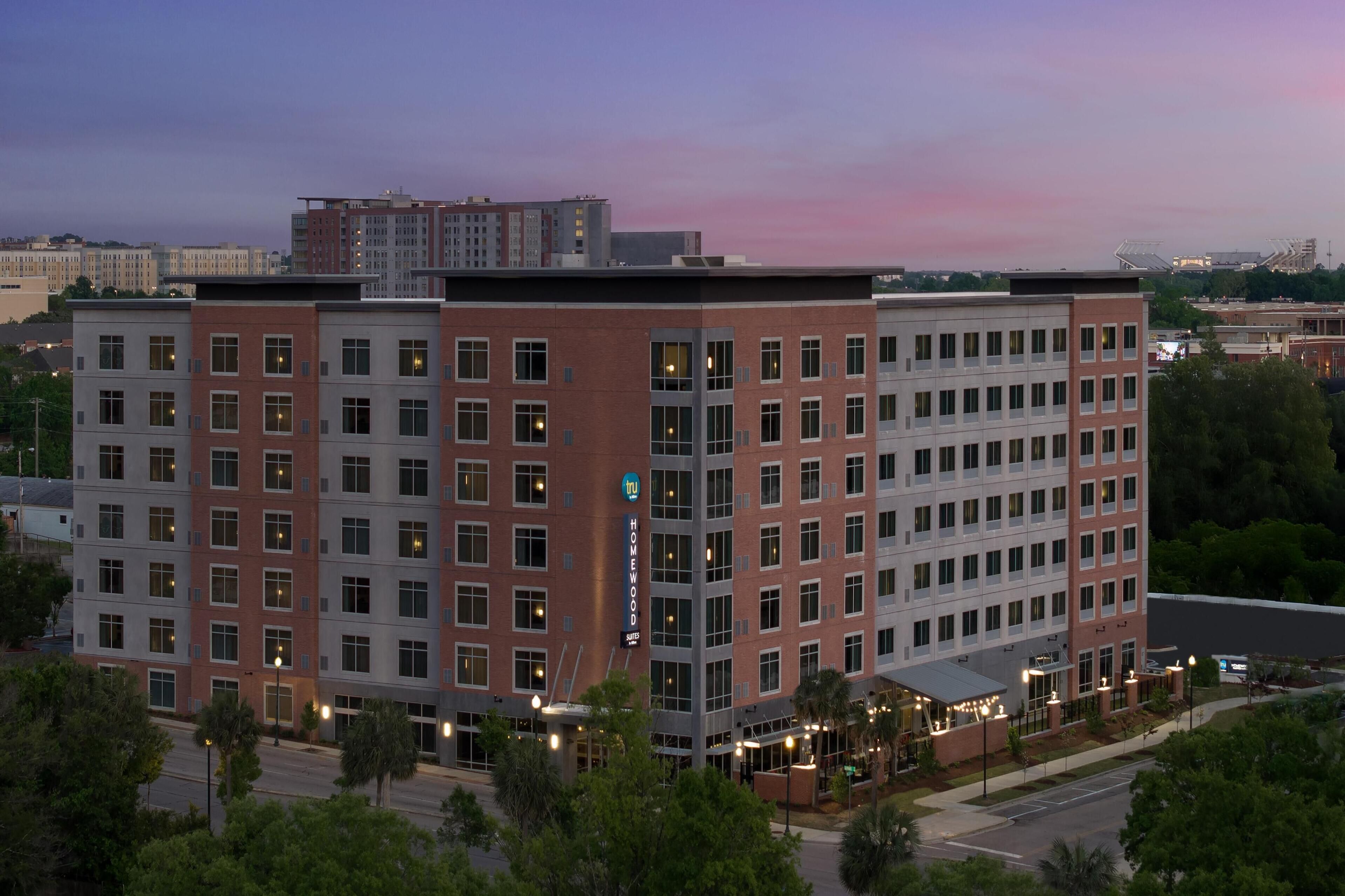A multi-story hotel with a modern architectural design, featuring a prominent "Homewood" sign.