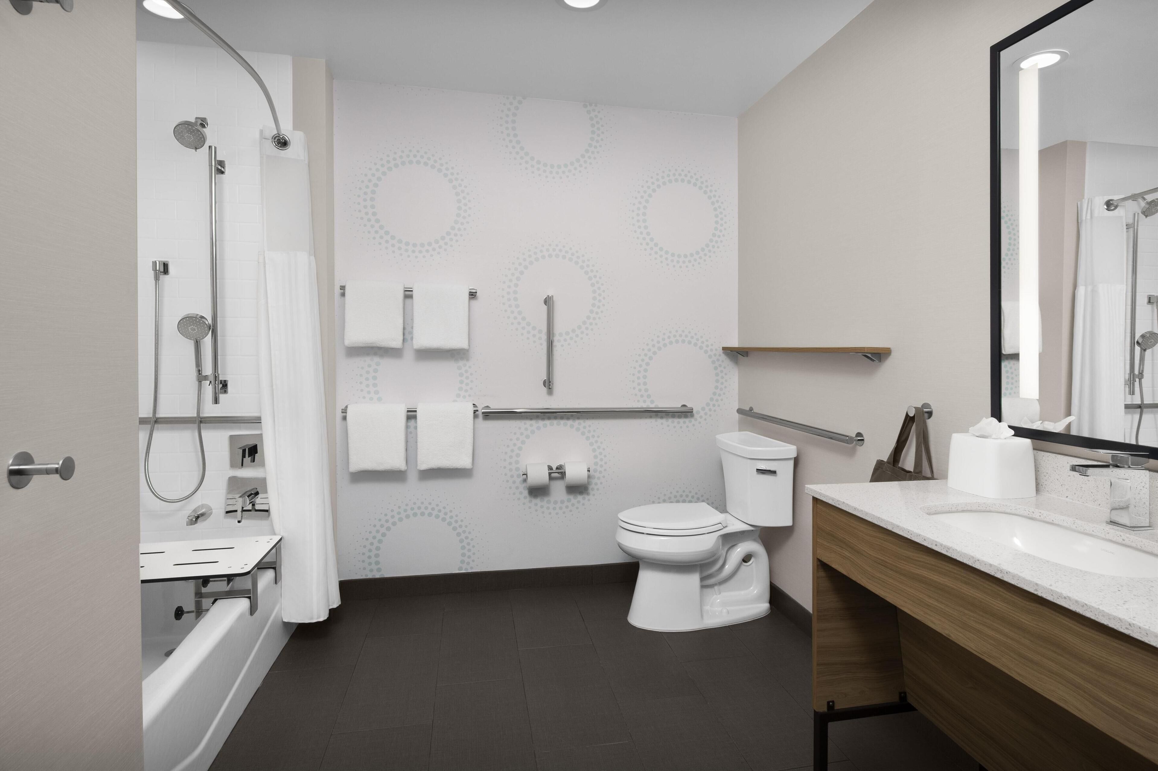 A modern bathroom with a bathtub, toilet, and sink.