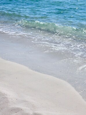 A beach with clear water and a sandy shore.