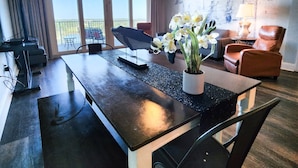 A modern living room with a dining table, chairs, a ceiling fan, and a view of the outdoors. - Gorgeous Set up! Dive into the best vacation with Best Amenities! (Panama City Beach)