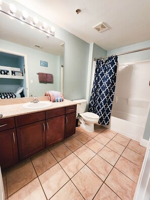 A bathroom with a vanity, sink, mirror, and a shower area. - Immaculate! Large and inviting! Dive into the best vacation NOW! (Panama City Beach)