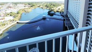 A high-rise hotel with a view of a lake and surrounding greenery. - Enjoy the heavenly views and dive into the magic of sunshine! (Panama City Beach)