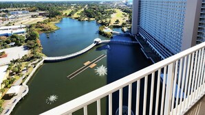 A high-rise hotel with a view of a lake and surrounding greenery.