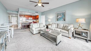 A spacious living room with a large sofa, a coffee table, and a ceiling fan. - Best Location, 3rd floor condo! Enjoy the incredible views and privacy! (Panama City Beach)