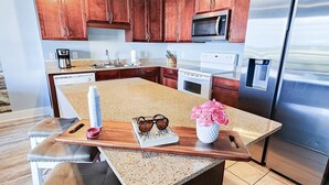Una cocina moderna con armarios de madera, electrodomésticos de acero inoxidable y encimera de granito.
