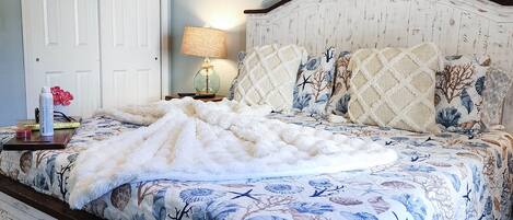 Un dormitorio con cama, mesita de noche, lámpara y una puerta.