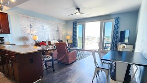 A spacious living area with a kitchen, dining table, and seating area. - Super Convenient 5th FLOOR- 537 !  LOCATION, AMENITIES, And Amazing Views! (Panama City Beach)