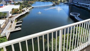 A view of a waterfront area with a dock, a building with a white facade, and a clear blue sky. - Super Convenient 5th FLOOR- 537 !  LOCATION, AMENITIES, And Amazing Views! (Panama City Beach)