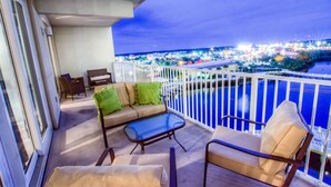 A balcony with a sofa, chairs, and a table.