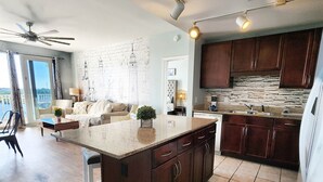 A spacious kitchen with a large island, dark wooden cabinets, and a stone backsplash.
