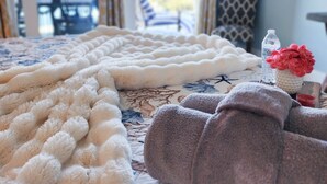 A cozy room with a large fluffy white blanket, a patterned bedspread, and a view of the outdoors through a sliding door. - Gorgeous Unit, Fantastic Location, Best amenities with a private boardwalk (Panama City Beach)