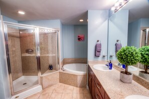 Ein modernes Badezimmer mit einer gläsernen Duschkabine, einer freistehenden Badewanne und einem Waschtisch mit Spiegel.