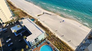 A hotel with a swimming pool, beach access, and a view of the ocean.