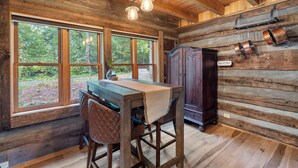 A rustic wooden interior with a bar area, large windows, and a pantry sign. - Luxury Log Cabin: Scenic Views Near Linville Falls (Marion)