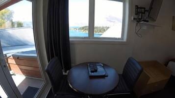 A room with a table, chairs, a window with a view, and a satellite dish.
