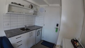 A compact kitchen with white cabinets, a sink, and a small countertop.