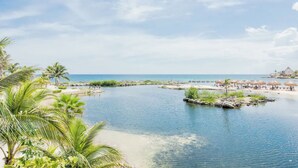 A tropical beach resort with a clear blue sea, palm trees, and a sandy beach area. - Spacious villa with 5 bedrooms and WiFi, AC in charming Caribbean community (SOLIDARIDAD)